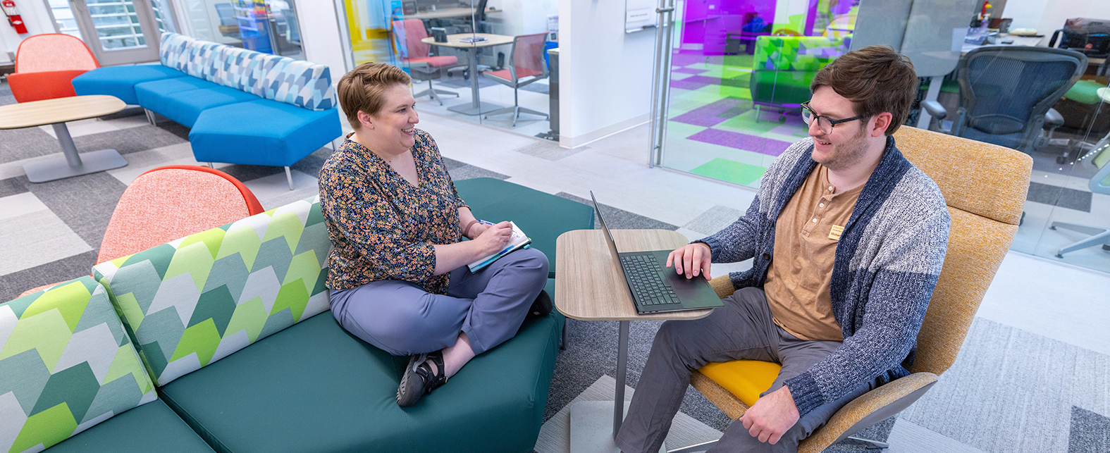 two librarians have a discussion in the Catalyst the space is open and colorful 